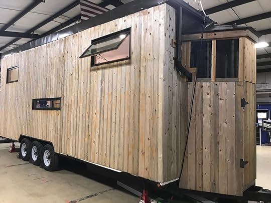 Rear view of the tiny house. Note the gutter and downspout, leading to the water collection and purification system inside.