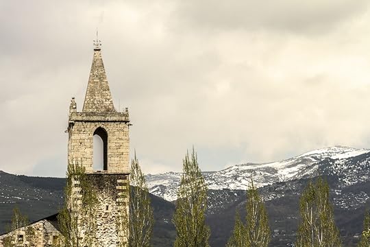 Church with the Pyrenees in the background in Llivia, Spain