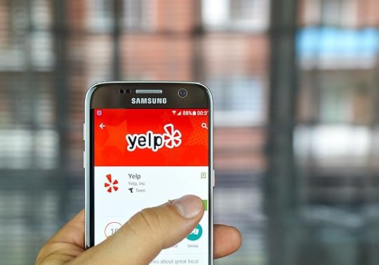 Yelp mobile app on screen Samsung S7 in hand