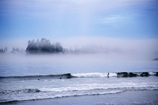 Surfers in Tofino with mist around it