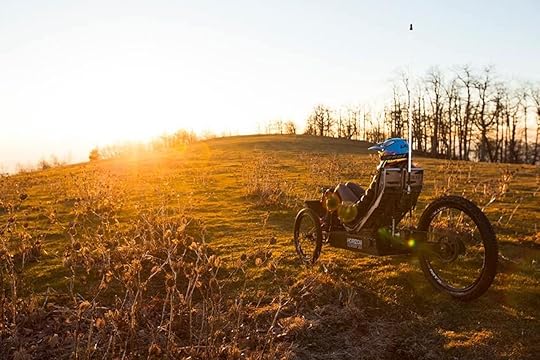 Person in a field on an Outrider bike at sunset