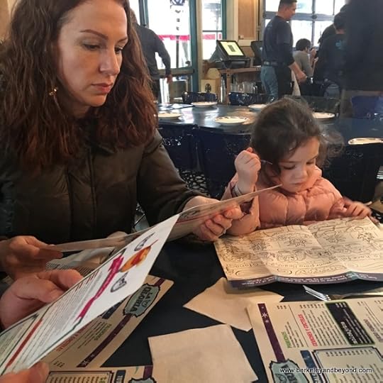 child and mother study menu at La Gloria in the Pearl in San Antonio, Texas