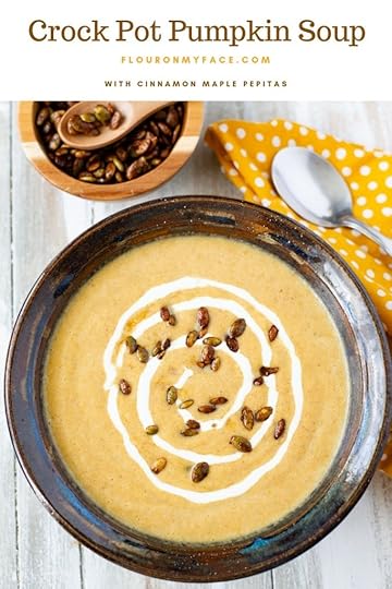 Crock Pot Pumpkin soup in a brown bowl, yellow napkin, spoon and small bowl of cinnamon maple pepitas
