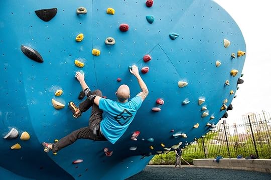 Rock climber on a blue rock-climbing structure