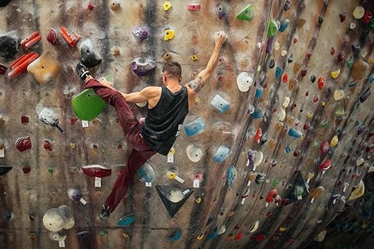 Man ascending rock wall in a rock climbing gym