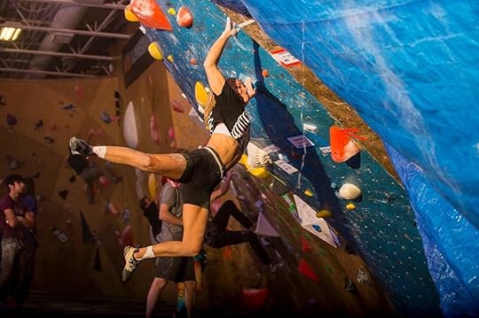 Rock climbing hanging off a rock wall in a climbing gym