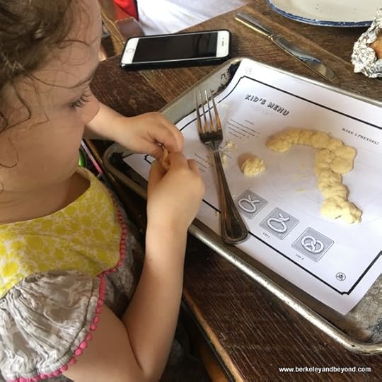 little girl plays with pretzel dough at Southerleigh Fine Food and Brewery in San Antoniio, Texas