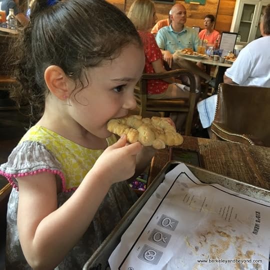 little girl eats baked pretzel she made at Southerleigh Fine Food and Brewery in San Antoniio, Texas