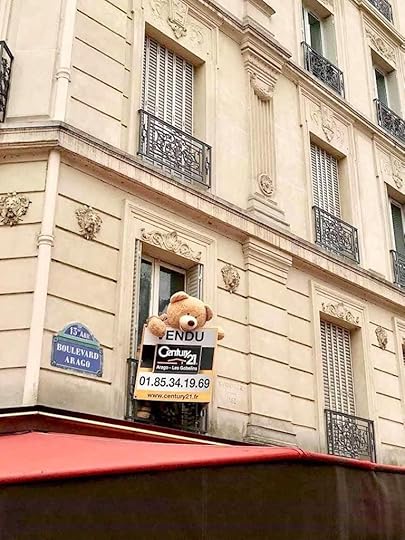 Giant teddy bear sticking its head out of an apartment window in Paris