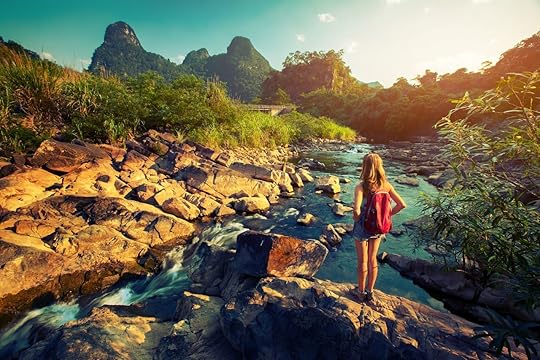 Woman hiker standing on the rock and enjoying view of the river