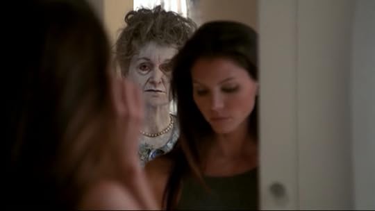 Cordelia is oblivious in front of her mirror as a ghostly lady (probably in her sixties) is reflected behind her.