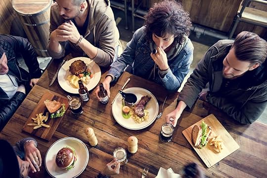 Friends sharing beer and food at Electric Works Fort Wayne, Indiana