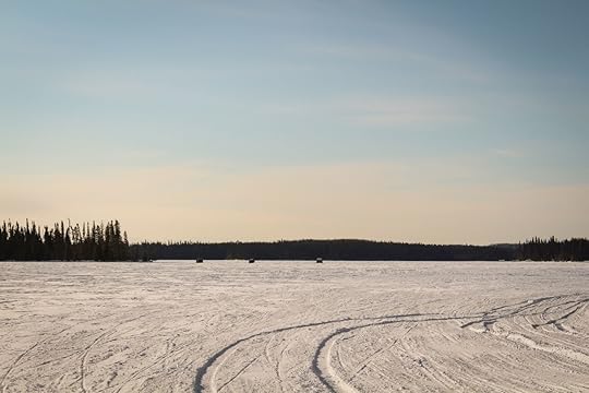 Frozen lake with a lot of anglers enjoying winter fishing