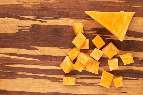 Cubes of marble cheese on wooden background