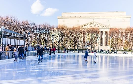 People ice skating in view of a state building