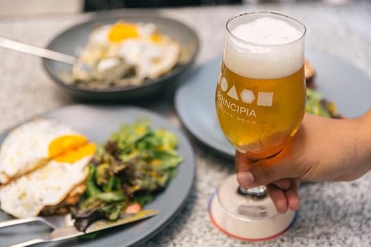 Person holding beer glass at Principia Tasting Room