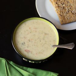 bowl of broccoli cheese soup with plate of crackers
