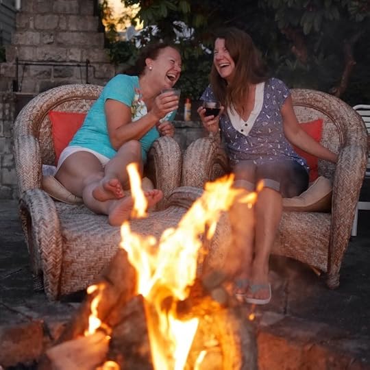 2 girls laughing by the fire