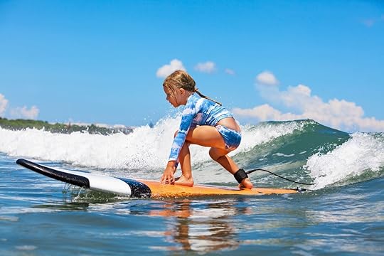 Little girl on a surf board riding a wave