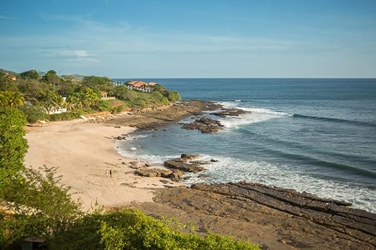 Rocky beach in Nicaragua with people walking in the distance