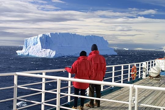 Cruise ship passengers looking at a beautiful iceberg at Antarctica