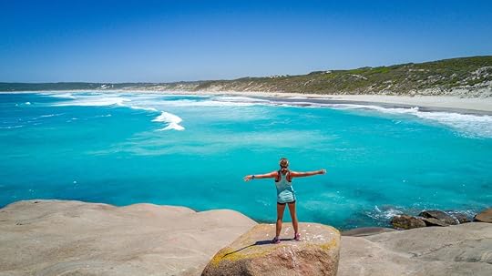 Woman standing on a rock in front of the ocean