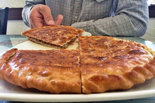 Man taking a slice of a stuffed, fried Chinese dish