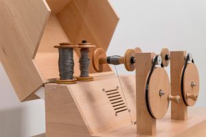 The Yarn Recorder can record and play sounds (Wooden device with two bobbins of yarn)