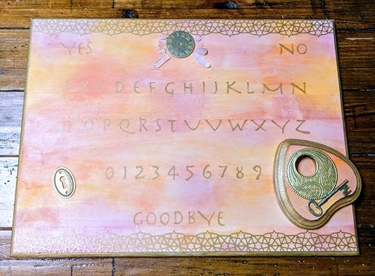 I made a ouija board. It's watercolor stained with pink and orange and brown and has gold lettering and embellishments like a keyhole and a watch face and various crystals.