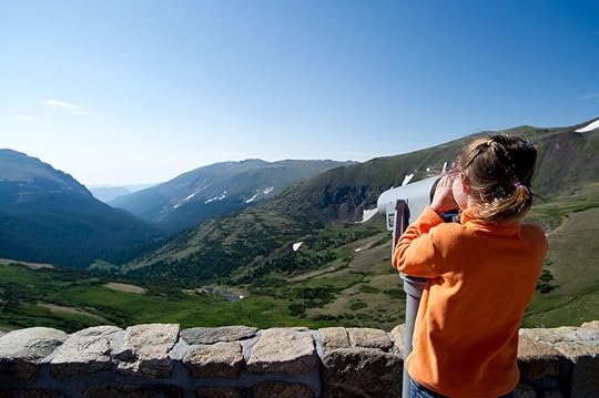 Young girl looking through a viewfinder in Estes Park