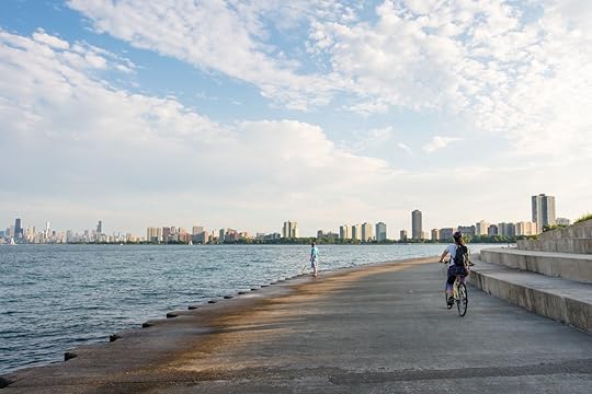 A cyclist rides along the park area at Montrose Beach, a popular area in Chicago during the summer that overlooks the skyline
