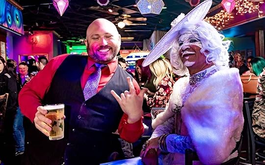 Two men, one in drag, enjoying themselves at a gay bar party