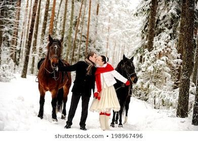 couple riding horses in the snow