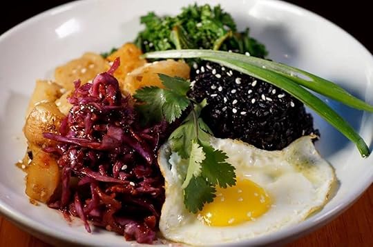 dish of black beans, slaw, potatoes, greens, and a fried egg