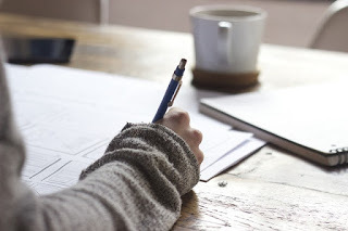 picture of woman with pen making notes on paper