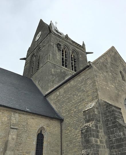 Close-up of church of Sainte-Mère-Église, France, showing memorial to paratrooper John Steele of the US 505th PIR, whose parachute caught on the steeple. He was taken prisoner by the Germans, but later escaped to fight again. (Photo: September 2017, Sarah Sundin)
