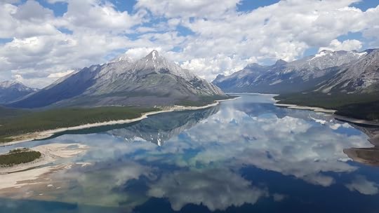 Mount Assiniboine under clouds reflected in a waterway