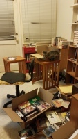 Untidy kitchen with bookshelves and cat in box