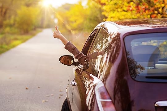 Person sticking hand out of car window, thumbs up