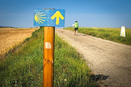Milemarker and hiker on the Camino de Santiago