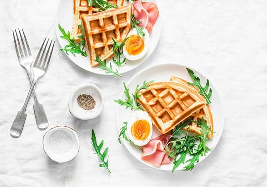 Served breakfast with potatoes savory waffles, boiled egg, ham and arugula on light background