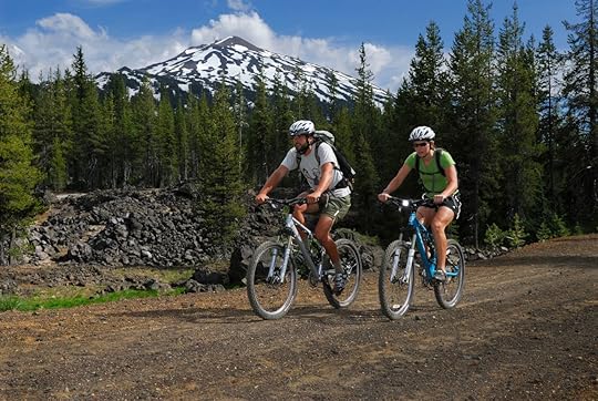 Mountain bikers traveling on dirt road under Bend Mount Bachelor, Oregon, United States