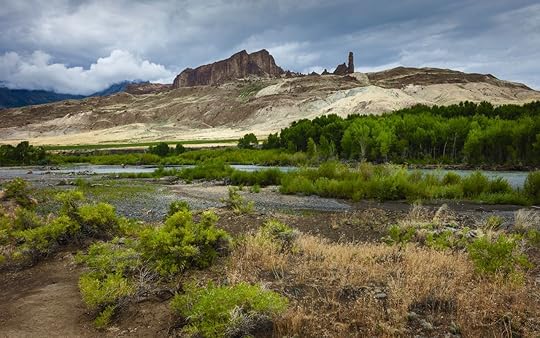 The arid landscape of the meadow with glimpse of Shoshone river and foothills of the Rocky Mountains on a late summer day near Cody, Wyoming