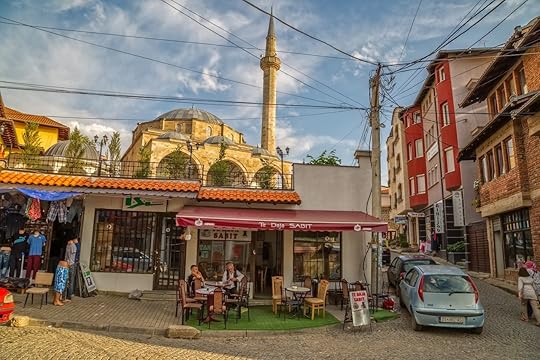 Two men resting with coffee under Fatih Mosque