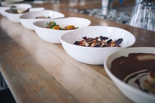 Bowls of artfully plated food on a wooden table