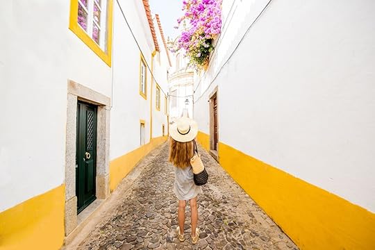 Young woman traveling on the street in the old town of Evora in Portugal