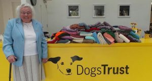 Maisie Green with a selection of the blankets and dog coats she's knitted for DogsTrust