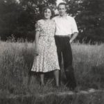 a young couple standing in a field