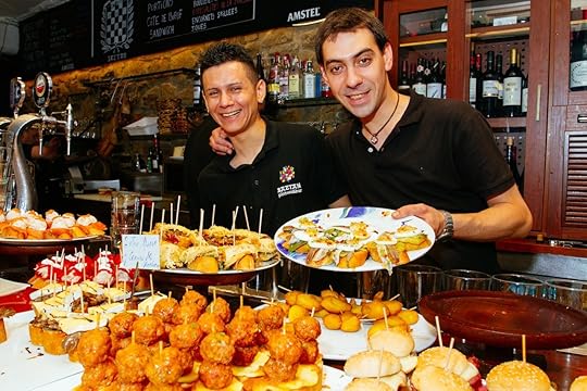 Two waiters show the tapas of the bar of a bar of San Sebastian