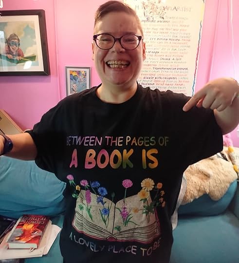 I just got the sweetest #bookish gift from reader & friend Lynn Postlewait – this T that says: Between The Pages of a Book Is a Lovely Place To Be! I heartily agree. I love bookish & #writerly things!<br /><br />It was such good timing, too. Yesterday I had a really rough day, harder than I’ve had in a while, severe depression and despair that periodically comes up from trauma and exhaustion and worry. Today’s been better but I’m still struggling with depression.<br /><br />But tonight I am going to celebrate with two neighbors on my getting a literary agent who I’m really excited about (who is also excited about me and my work), and this bookish t-shirt is perfect for that. It also helps lift my spirits. We all need to know that we are cared about. I hope you know that you are. And we all need to know that things will get better. Sometimes we just need little reminders of that. Today this is mine.<br /><br />#friendsarefamily #bookshirt #readershirt #writershirt #bookishgifts #readergifts #writergifts<br />#cherylrainfield #YAwriter #LGBTQwriter #booknerd #bookworm #ireadYA #survivor #feminist